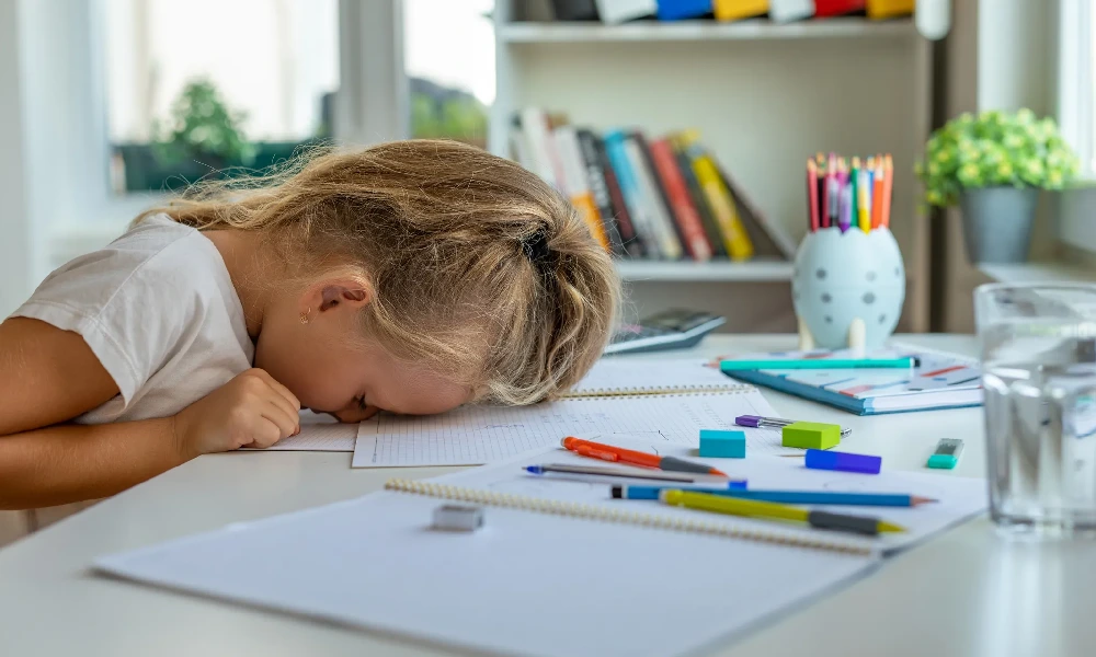 کودکی که سرش را روی میز قرار داده است | بیماری ADHD